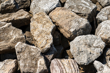 Closeup of a breakwater made of giant boulders by the sea, full frame. Liguria, Italy, Europe