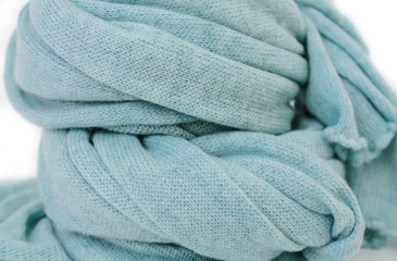 Soft woven fabric scarf coiled on white background