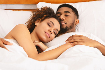 Loving couple sleeping in bed and hugging