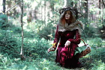 Fototapeta na wymiar The red-haired witch holds a ritual with a crystal ball