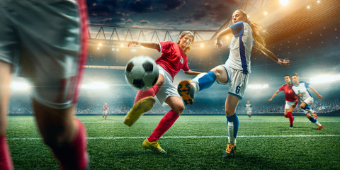 Female Soccer players performs an action play on a professional soccer stadium. Girls playing soccer - Powered by Adobe