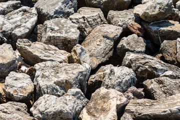 Closeup of a breakwater made of giant boulders by the sea, full frame. Liguria, Italy, Europe