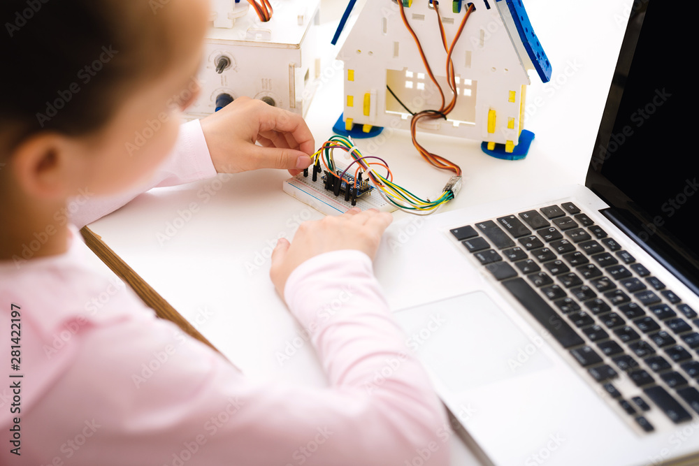 Poster Schoolgirl programming robot with laptop computer at lesson