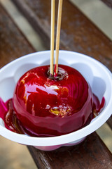 Apple in raspberry syrup on a stick