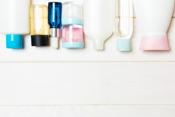 Flat lay composition with cosmetic and cream bottles on wooden background. Beauty products concept with copy space