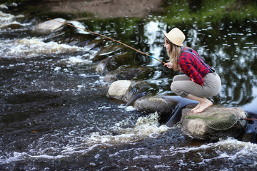 Girl by the river with a fishing rod