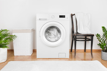Interior of laundry room with washing machine and laundry basket