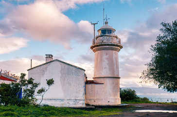 Historical Aegean lighthouse against a blue sky and clouds background in Bodrum, Turgutreis, Akyarlar, Turkey.