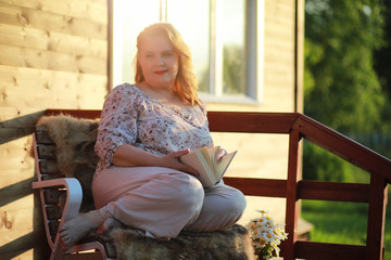 An elderly woman on the porch of a house