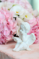 Statuette of a white sweet angel on a floral background