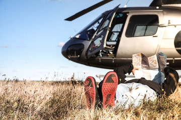 Pilote allongé regardant sa carte aéronautique et hélicoptère as-350 écureuil  