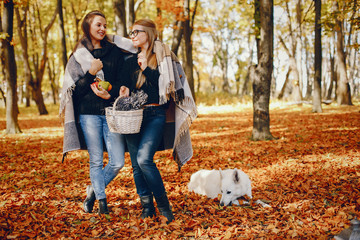 Beautiful girls in a park. Cute ladies in a stylish clothes.
