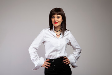 Smiling young business woman portrait on gray wall background