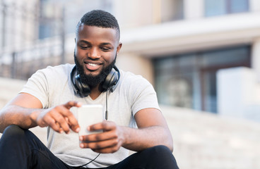 African american guy having a rest sitting on stairs outdoor