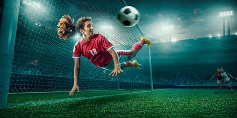 Female Soccer player in action on a professional soccer stadium. Girl playing soccer