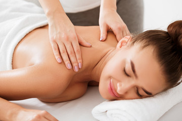 Woman enjoying back and neck massage in the health spa