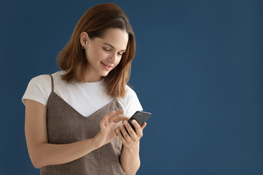 Woman Using Smartphone Posing Isolated On Dark Blue Studio Background