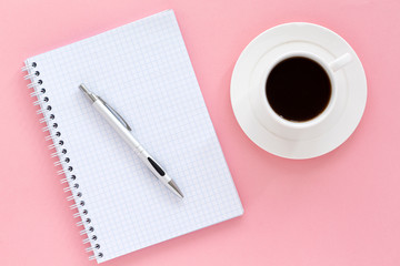School notebook on a pink background. Blank notepad white page, pen and coffee, color background. Top view, space for text.   