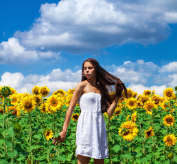 Portrait of a young beautiful girl in a field of sunflowers
