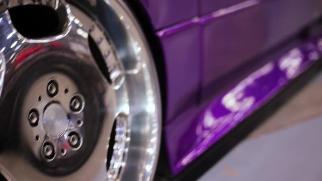 Close up of purple car wheel with custom disk of tuned low rider sport car, toned