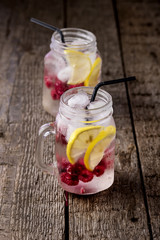 Infused Water with Lemon and Raspberry Healthy Detox Drink Cold Berry Fruit Lemonad in Glass Jars Wooden Background Vertical