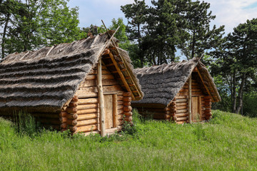 Historic Slavic dwelling on the Molpir hill in the Little Carpathians. Two wooden cottages with straw roof on the hillfort.