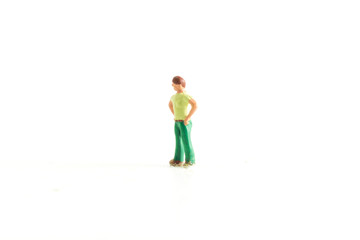 Fototapeta na wymiar Miniature person with there hands on there hips on a white isolated background
