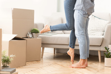 Happy Man Lifting Woman Among Moving Boxes In New House