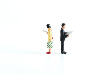 Miniature People Looking at Media/Newspaper/Phone Standing on a White Isolated Background