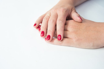 Beautiful woman's hands on light background. Care about hand. Redl manicure, clean skin. Bright nails with polish on white background