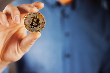 Cryptocurrency golden bitcoin coin in man hand