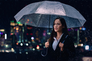Business woman she is going home she covered the umbrella and rain. © torwaiphoto