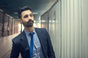 Portrait of young Pakistani businessman wearing formal wear standing in construction tunnel.