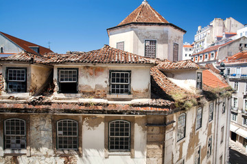 Fototapeta na wymiar Rustic texture of walls and tile roofs over the old streets of historical city district. Lisbon.