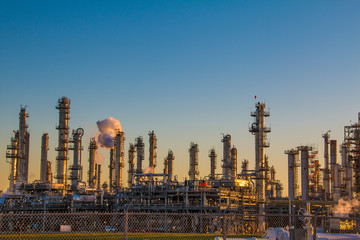 Oil refinery stacks against a landscape