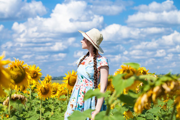 Portrait of a young beautiful girl in a field of sunflowers