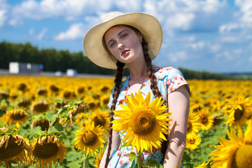 Portrait of a young beautiful girl in a field of sunflowers