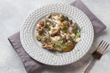 Stewed mushrooms in sauce with sour cream and cheese on a plate