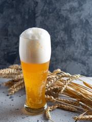 A glass of wheat beer with a foam cap