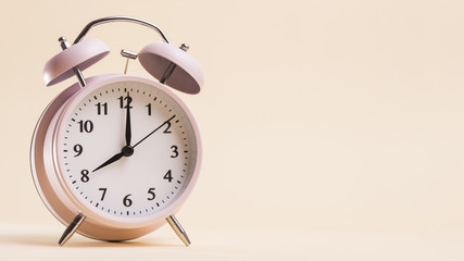 Vintage alarm clock showing 8'o clock time against beige background