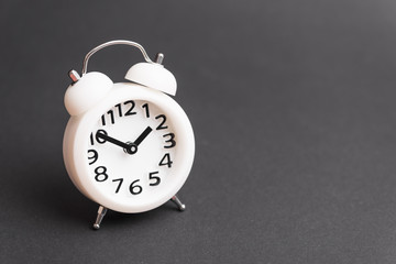 White alarm clock on gray background