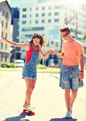 summer holidays, extreme sport and people concept - happy teenage couple riding short modern...