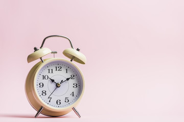 Retro alarm clock on the pink background
