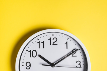 Round clock face against yellow backdrop