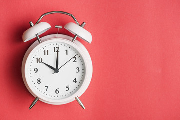 Close-up of a alarm clock on red background