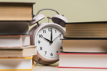Alarm clock showing the time 10'o clock behind the bookshelf