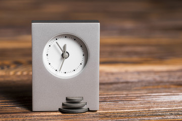 Fototapeta na wymiar Gray rectangular clock on wooden textured background