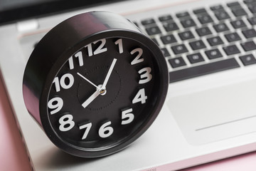 Close-up of round black clock on laptop
