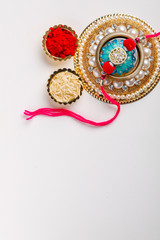 Indian festival Raksha Bandhan , Rakhi with rice grains, kumkum on Decorative plate , A traditional Indian wrist band which is a symbol of love between Brothers and Sisters