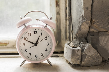 Fototapeta na wymiar An alarm clock on old windowsill